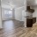 an open room leading into a kitchen and living room with wood floors