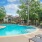 a pool with lounge chairs and trees