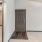 an empty entryway with a door and a bedroom adjacent