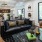 a lounge room with a black couch a table windows and a common area